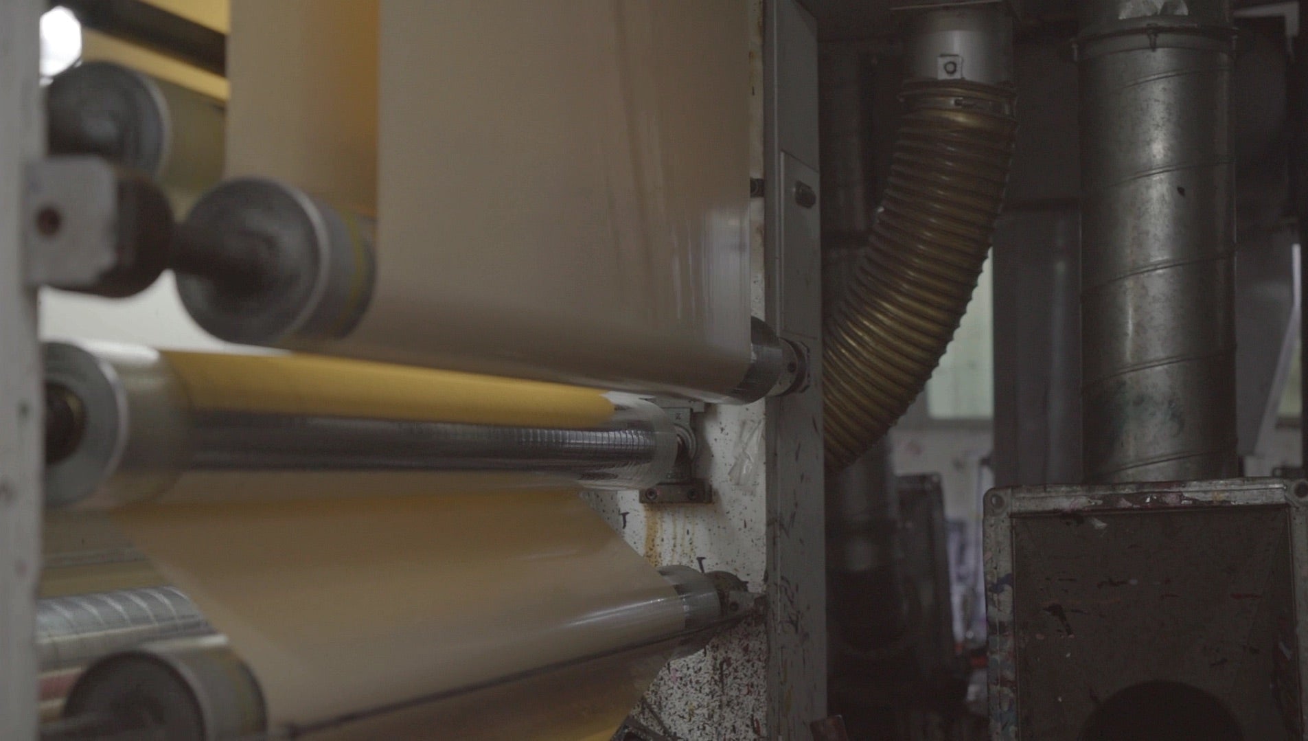 Wall covering film running through a printing press on the factory floor