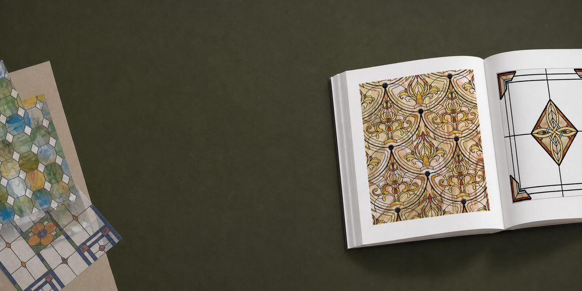 An open reference book of stained-glass pattern plates beside printed film samples.